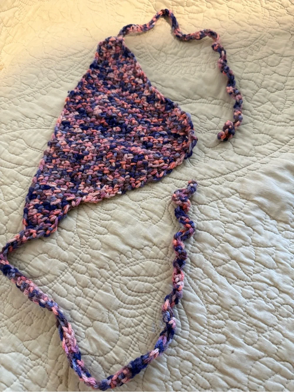 Handmade crochet bandana in pink, blue, and purple marbled yarn.